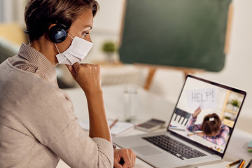 Female teacher feeling worried abut her sad student during online class due to COVID-19 pandemic.