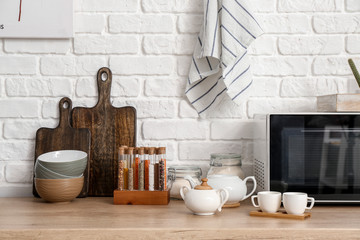 Set of utensils with microwave oven on kitchen counter