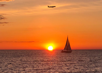 Obraz na płótnie Canvas Sunset on the Black sea, a yacht and a plane high in the sky. Raster image.