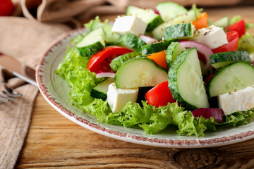 Plate with tasty cucumber salad on table, closeup