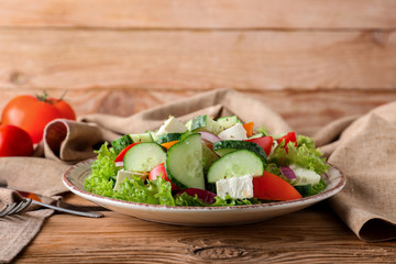Plate with tasty cucumber salad on table