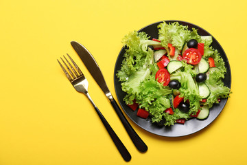 Plate with tasty cucumber salad on color background