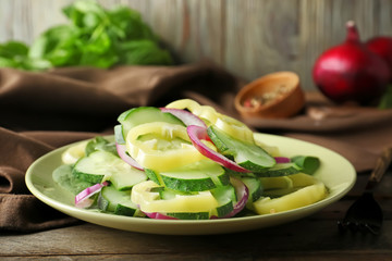Plate with tasty cucumber salad on table