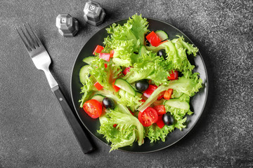 Plate with tasty cucumber salad on dark background