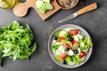 Plate with tasty cucumber salad on dark background