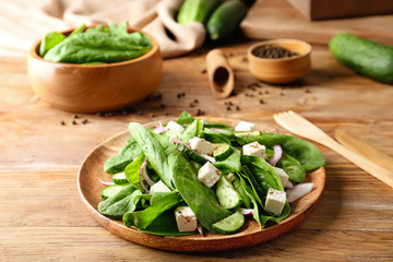 Plate with tasty cucumber salad on table