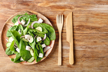 Plate with tasty cucumber salad on table