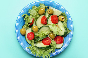 Plate with tasty cucumber salad on color background
