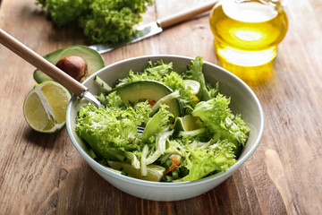 Bowl with tasty cucumber salad on table