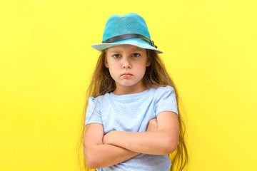 the concept of travel. portrait of a girl in a blue hat with glasses on a yellow background.