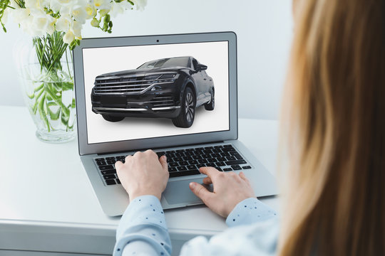 Buying online. Woman choosing car using laptop, closeup view