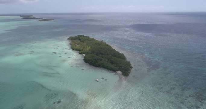 Aerial view, divers and boat in Maseta Cote island Caribbean Sea. .Moving backwards. constant altitude right turn. 29 fps