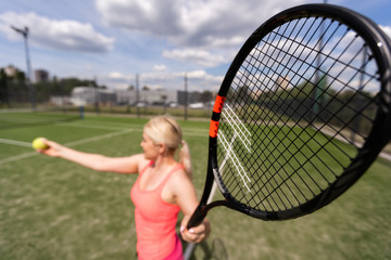 Pretty sportswoman with racquet at the tennis court. Healthy lifestyle