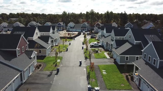 Drone shot down the road of a housing development 