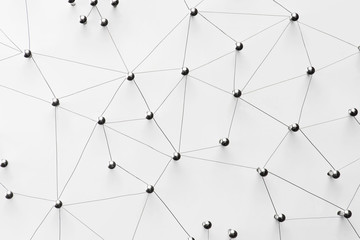 Linking entities. Monotone.Network,  networking, link, social media, SNS, internet communication, telework, remote working abstract. Top view. Web of thin silver wires on white background.