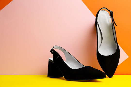 Stylish black female shoes on color background. Space for text