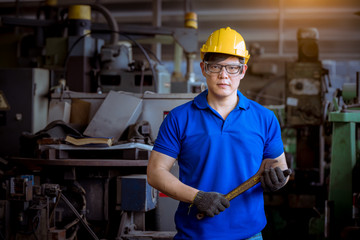 Portrait of industry engineering wear causal uniform posing hold wrench standing on control operating machine work in industry factory background.