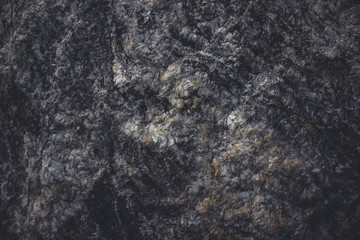 Textured stone background made of dark cobblestone