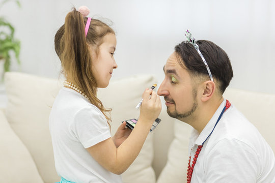 Side view of daughter doing makeup for her daddy.