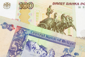 A macro image of a Russian one hundred ruble note paired up with a colorful two dollar bill from Belize.  Shot close up in macro.money, currency, mint, mints, change, small, monies, currencies, close,