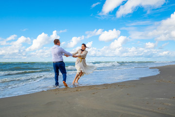 Happy couple dancing near waving sea