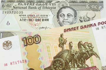 A macro image of a Russian one hundred ruble note paired up with a grey Ethiopian one birr bill.  Shot close up in macro.