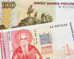 A macro image of a Russian one hundred ruble note paired up with a red and white one lev bank note from Bulgaria.  Shot close up in macro.