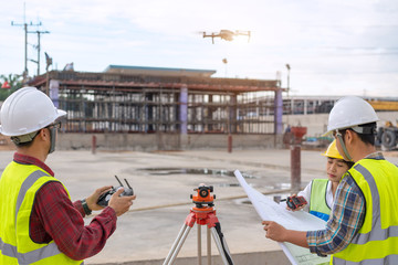 Drone operated by construction worker on building site,flying with drone. - 372167351