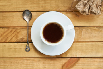 White cup of strong coffee on wooden background