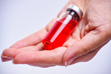 Woman hand with medical ampoule vial for infection. Corona virus infection, COVID-19, nCoV-2019 vaccine. Glass bottle with hand isolated on white background. 