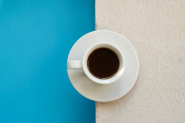 White cup of strong coffee standing on a stone background Copy space