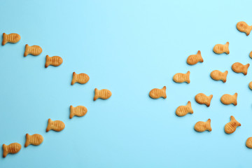 Delicious goldfish crackers on light blue background, flat lay