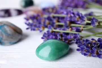 Fototapeta na wymiar Gemstones and healing herbs on white wooden table, closeup