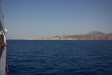 Greece. Rhodes island. Rest at the sea. Euro-trip. Sea water surface. Mountains in the background.