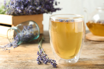 Fresh delicious tea with lavender in glass on wooden table