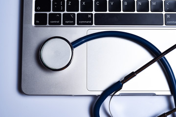 Doctor's office  with modern workplace in medical clinic. Laptop and stethoscope on the table top view.