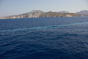 Fototapeta premium Greece. Rhodes island. Rest at the sea. Euro-trip. Sea water surface. Mountains in the background.
