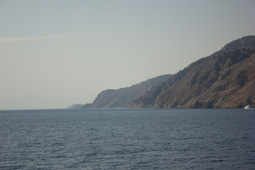 Fototapeta na wymiar Greece. Rhodes island. Rest at the sea. Euro-trip. Sea water surface. Mountains in the background.
