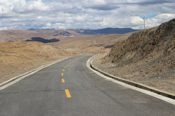 Road running through mountains in Tibet, China