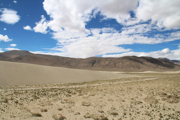 View of the mountain and sand dune with dirt road near Tingri on the way to Everest Base Camp, Tibet, China