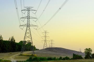 Electricity pole with silhouette sunset sky, Electricity pylon with shadow of tree in dawn time, Electricity power transmission line on sunset with copy space, Electricity pylon on orange sky