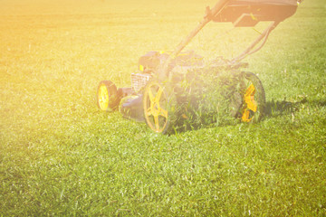 Mowing the grass at a football stadium on a summer sunny day.