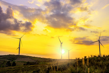 Night scene of landscape mountain view with windmills on the hill with sunset sky, Wind turbine generator to build electricity power in rural area, Electricity power concept