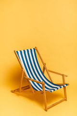  blue and white deckchair on yellow with copy space