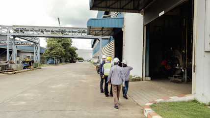 Engineers are walking through industry manufacturing factory, Safety patrol in manufacturing area, Cooperation by engineer and technician to check abnormality in factory