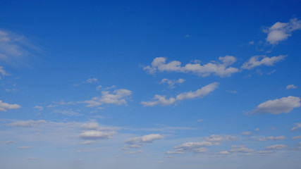 Naklejka na ściany i meble Blue spring sky with white clouds. Beautiful background.