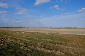 Beautiful cloudy sky over farmland. Spring landscape.