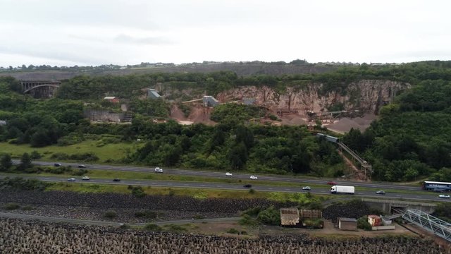Cemex mining site on North Wales expressway traffic aerial rising push in view over construction site