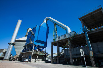 Mynaral, Kazakhstan: Modern Jambyl Cement plant. Hopper, silo and factory chimney on blue sky. Panorama view.