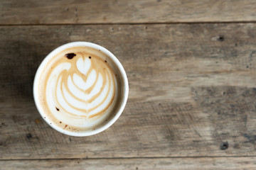 Coffee cup with latte art foam on wood table in coffee shop with copy space.Coffee is one of the most popular beverages.Improve Energy Levels and Burn Fat